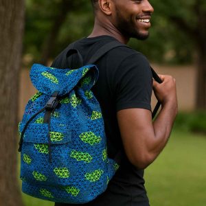 Ugandan man putting a Bible and notebook into a handmade African Kitenge drawstring backpack with bold traditional pattern