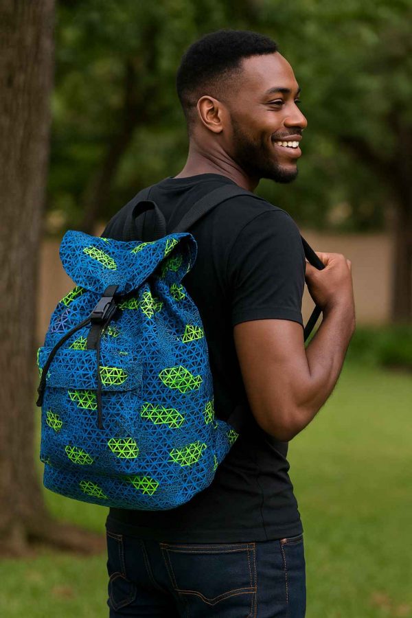 Ugandan man putting a Bible and notebook into a handmade African Kitenge drawstring backpack with bold traditional pattern