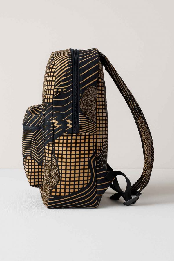 Studio side view of an African Kitenge print backpack with curved straps and utility pockets