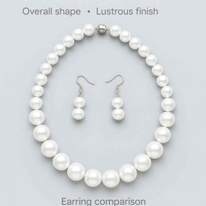 Flat-lay top view of pearl-style necklace and earrings showcasing bead gradation and shape