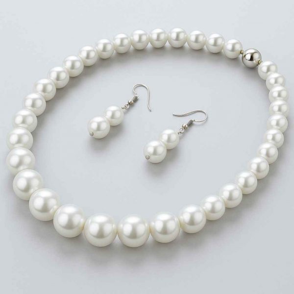Angled studio view of pearl-style necklace and matching earrings, highlighting curve and reflection