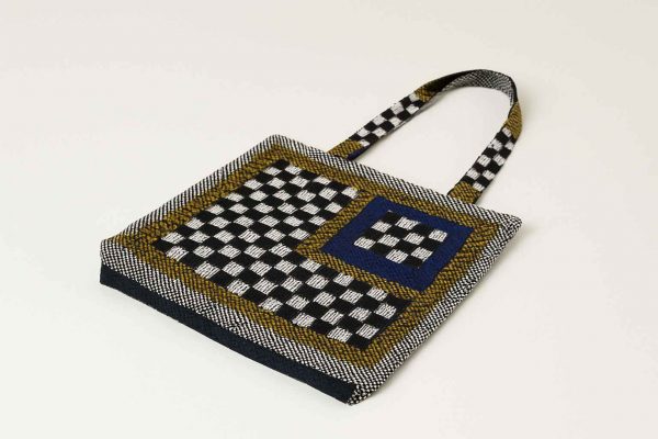 Bottom view of woven checkerboard tote bag showing thickness and base design