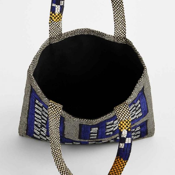 Interior view of woven checkerboard tote bag with open top and fabric lining