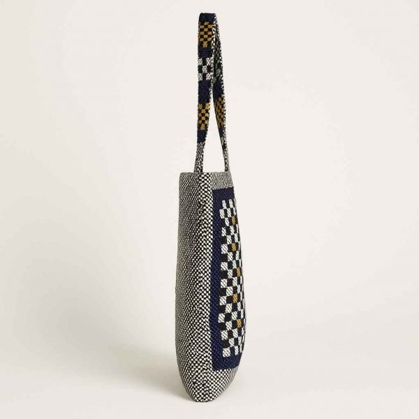 Left side view of a woven checkerboard tote bag with shoulder straps