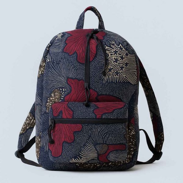 Handmade African Kitenge backpack showing a tilted view with traditional prints in blue, red, and white