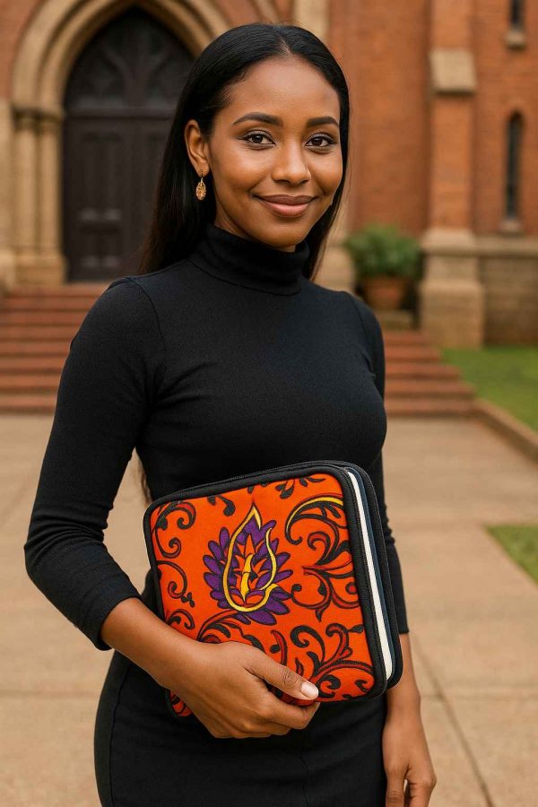 Ugandan woman holding orange African Kitenge Bible cover outside church