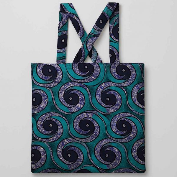 Front studio view of African kitenge tote bag in teal, purple, and blue swirl pattern