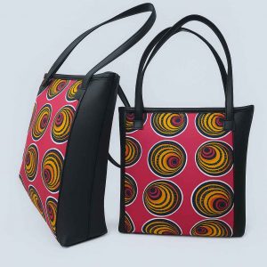 Ugandan woman holding African Kitenge tote pink yellow spiral bag
