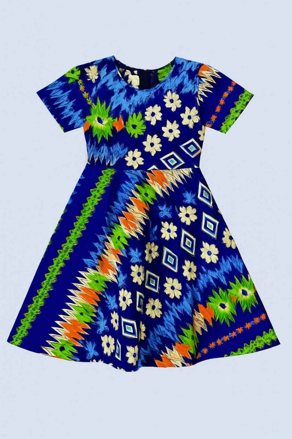 Close-up of the lower half of a kitenge girl's dress showing vivid geometric and floral prints