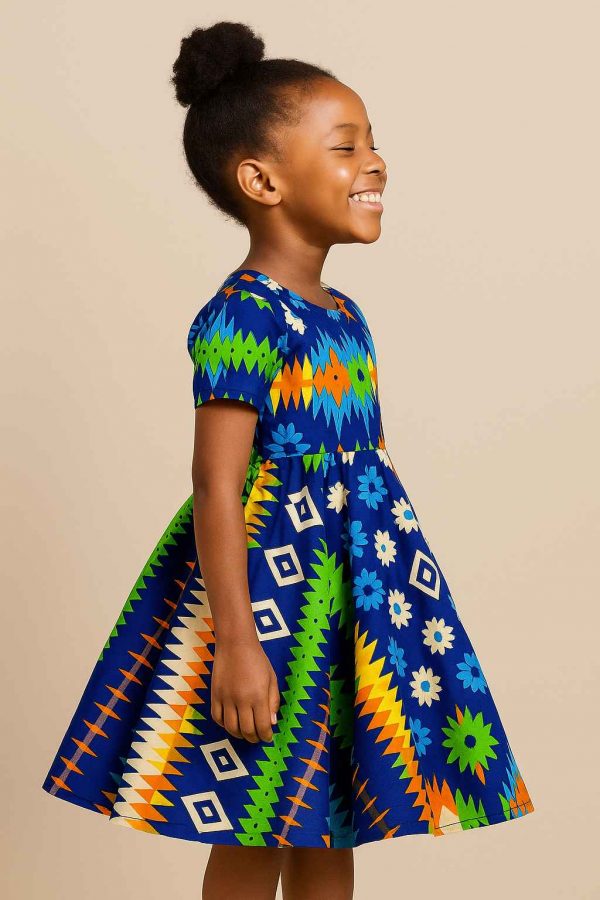 Young African girl wearing a vibrant multi-pattern kitenge flare dress, right profile view