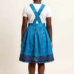 Back view of a young African girl wearing a kitenge suspender skirt with crossed suspenders