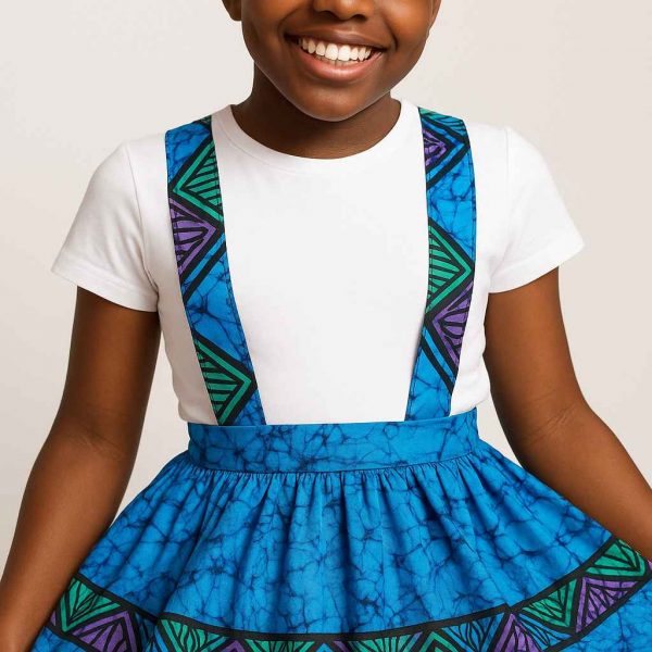 Close-up of vibrant African kitenge suspender skirt worn by a smiling girl
