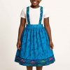 Front view of a young African girl wearing a kitenge suspender skirt and white shirt