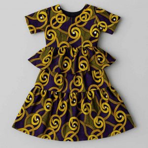 Top-down flat-lay view of a girls’ African peplum dress with layered skirt and short sleeves, arranged neatly on a studio background
