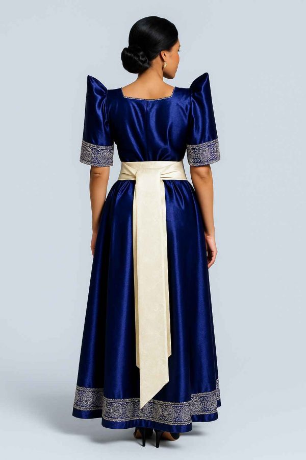 Elegant Ugandan woman wearing blue Gomesi with white sash back view