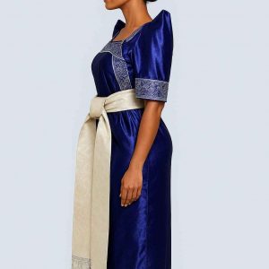 Elegant Ugandan woman wearing blue Gomesi with white sash side view
