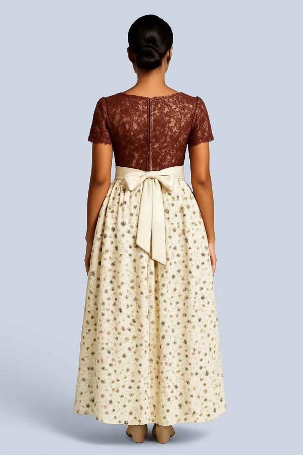 Back view of a young African woman in an elegant party dress with a floral cream skirt and lace bodice