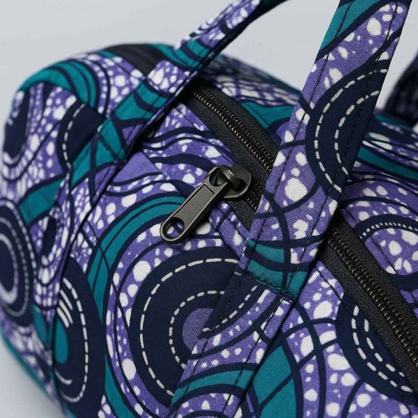 Close-up image of African print duffle bag showing stitching, fabric, and zipper