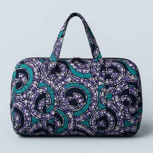 Studio image of a multipurpose African print travel bag front-facing on soft background