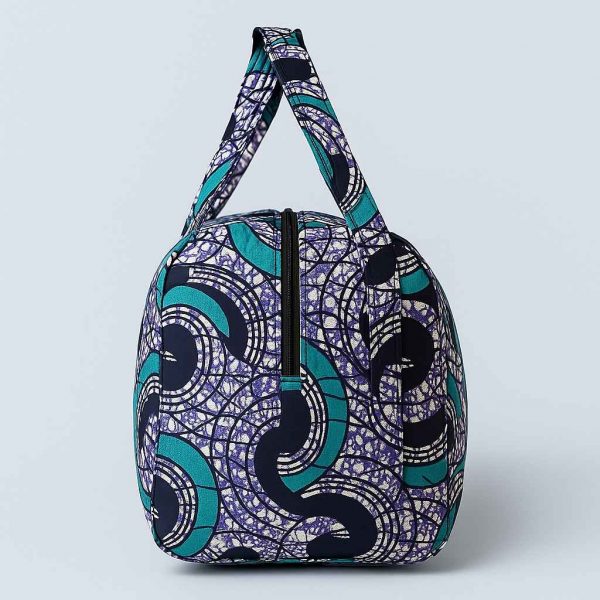 Side studio image of African print duffle travel bag showing strap profile