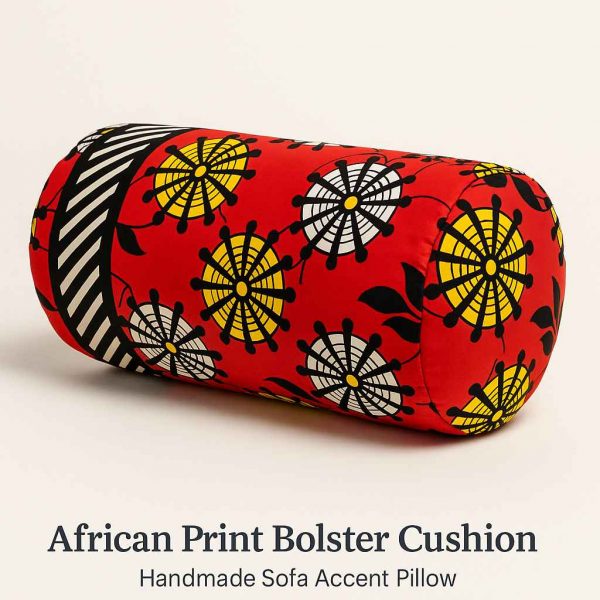 Angled studio view of a handmade African print bolster cushion with bold red, black, and yellow patterns