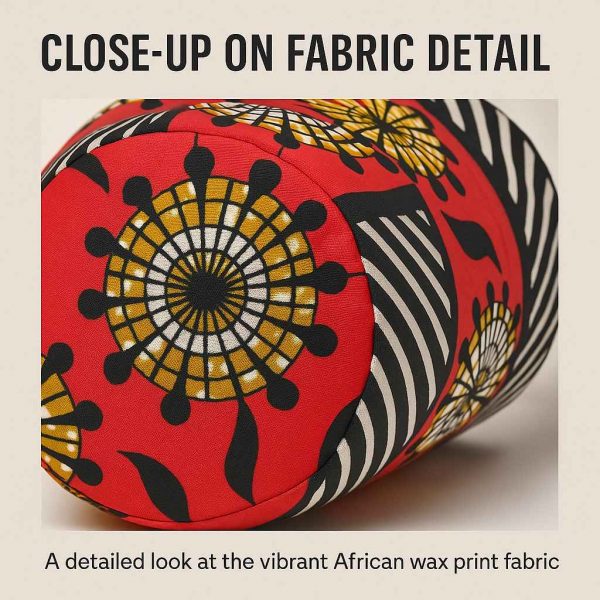 Close-up studio image of African print bolster cushion showing precise stitching and vivid red, yellow, and black fabric