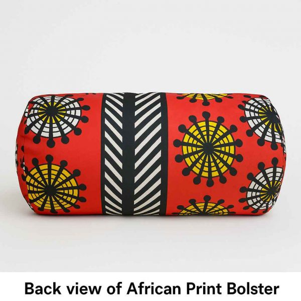 Rear studio view of a handmade African print bolster cushion showing fabric pattern and zipper placement