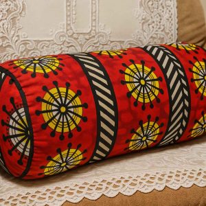 African print bolster cushion placed on a beige armchair with white lace cover in a cozy living room setting
