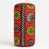 Side studio view of an African print bolster cushion showing rounded edge and vibrant African fabric