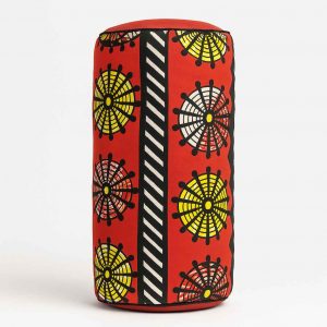 Side studio view of an African print bolster cushion showing rounded edge and vibrant African fabric