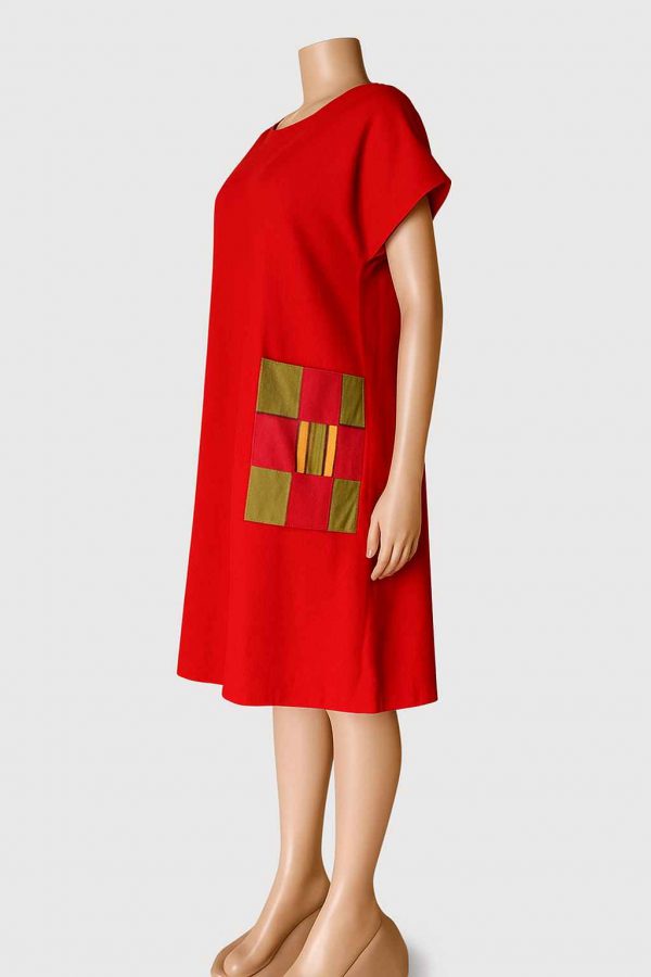 Right side view of a red knee-length handmade free dress with kitenge patch pocket