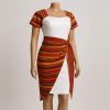 Angled view of a white cultural wrap dress with colorful side sash
