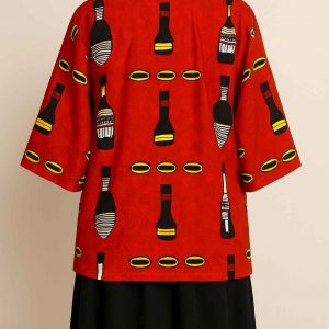 Back view of a red African Kitenge jacket with medium sleeves, styled over a dark skirt and displayed on a mannequin.