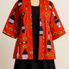 Front view of a mannequin dressed in a red African print jacket with medium sleeves, styled over a dark modest skirt.