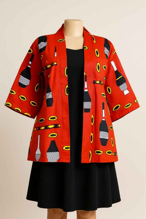 Front view of a mannequin dressed in a red African print jacket with medium sleeves, styled over a dark modest skirt.