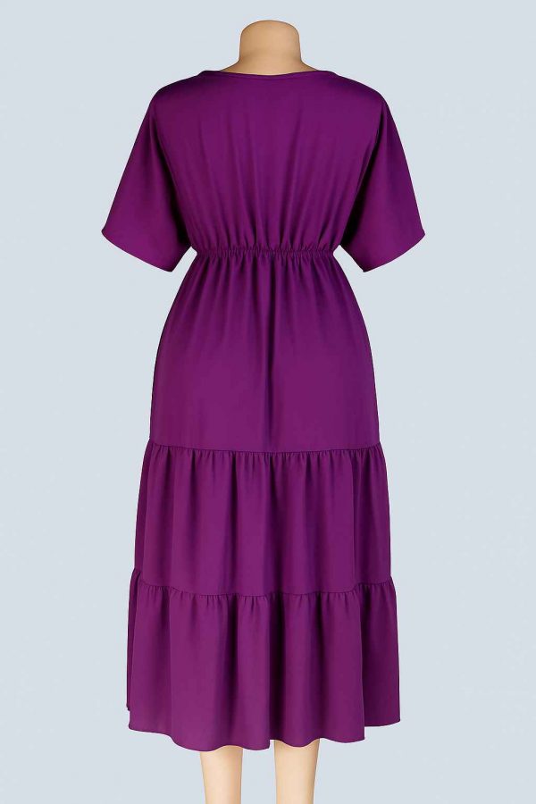 Back view of a royal purple tiered midi dress displayed on a mannequin in a studio setting