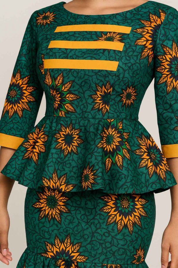Close-up of the bodice and peplum waist of a women’s African dress with yellow trim and intricate pattern detail