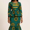 Studio portrait of a stunning African woman wearing a green, gold, and orange peplum dress with modest fit and mermaid silhouette