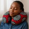 African woman resting with African print U-shaped neck pillow on sofa