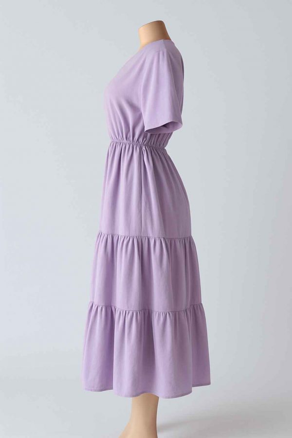 Side view of a modest lavender midi dress with elastic waist, short sleeves, and two softly gathered tiers